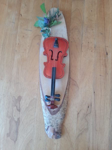 Petit violon décoratif sur planche de bois naturel